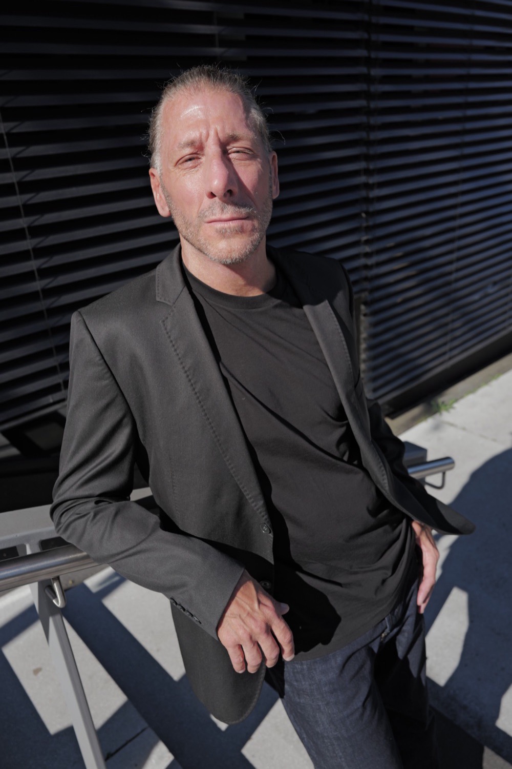 Portrait im Sonnenlicht, lässig an ein Geländer gelehnt