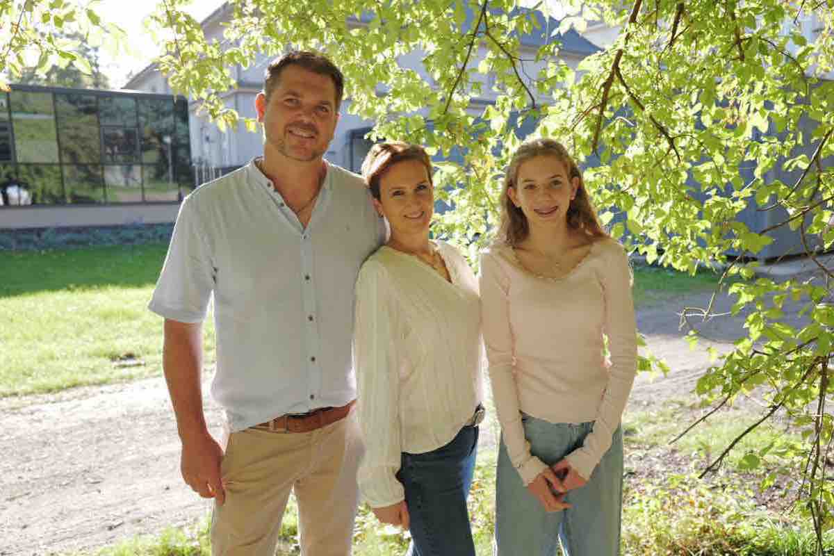 Familienportrait unter hellgrünen Blättern im Park