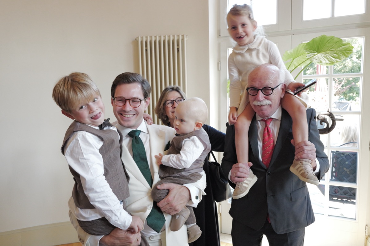 Opa mit Familie und Enkelkindern im hellen Saal