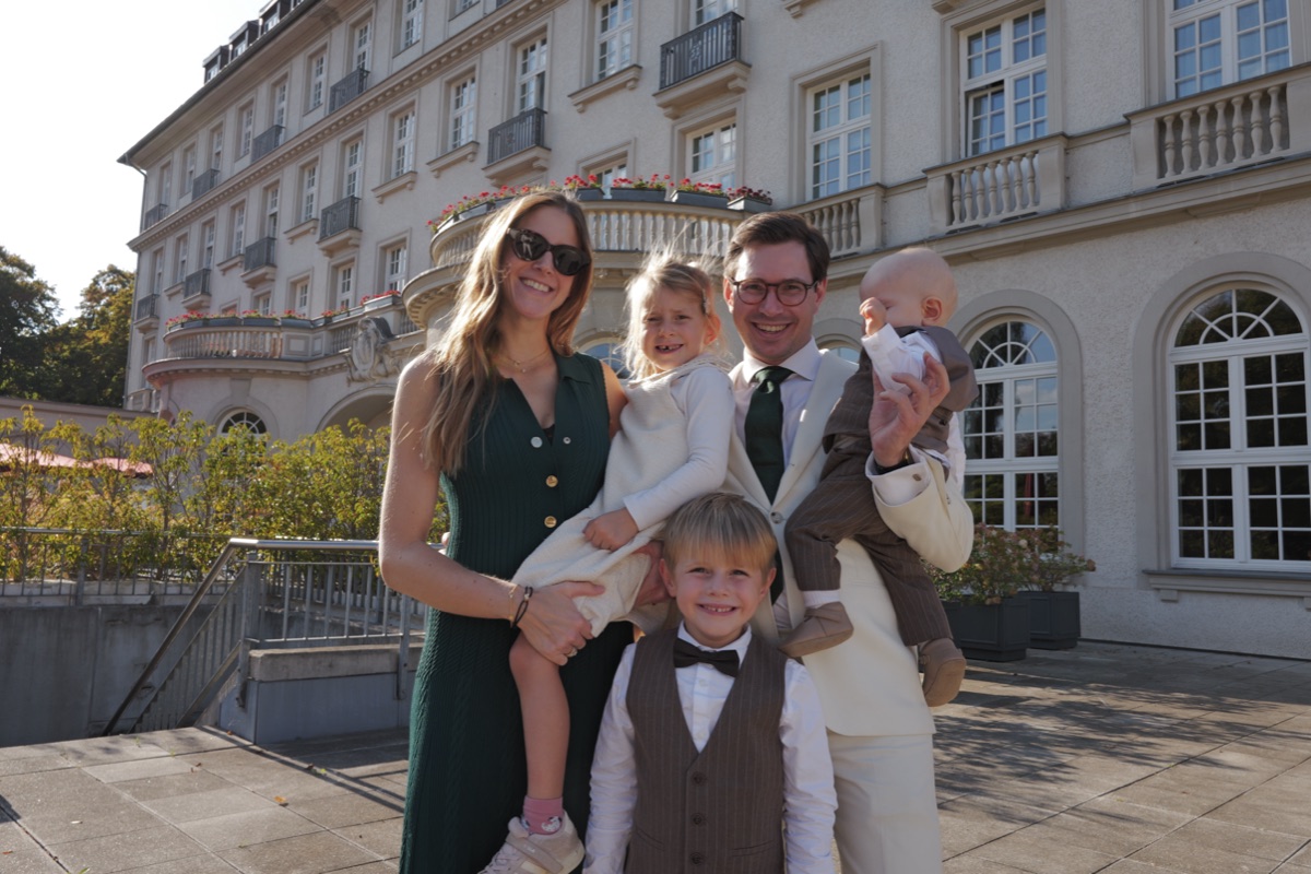 Familie mit drei Kindern vor der Fassade des Quellenhofs