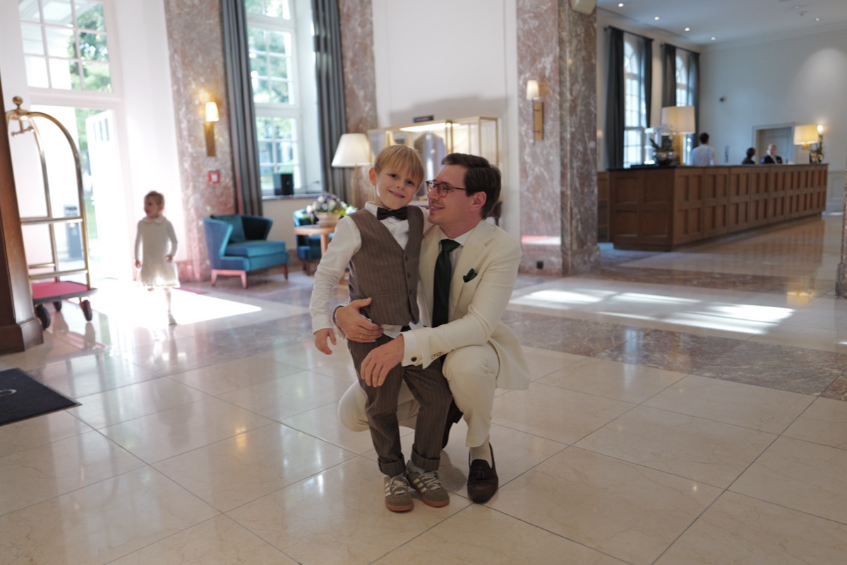 Vater hockt mit seinem Sohn in der Hotelhalle